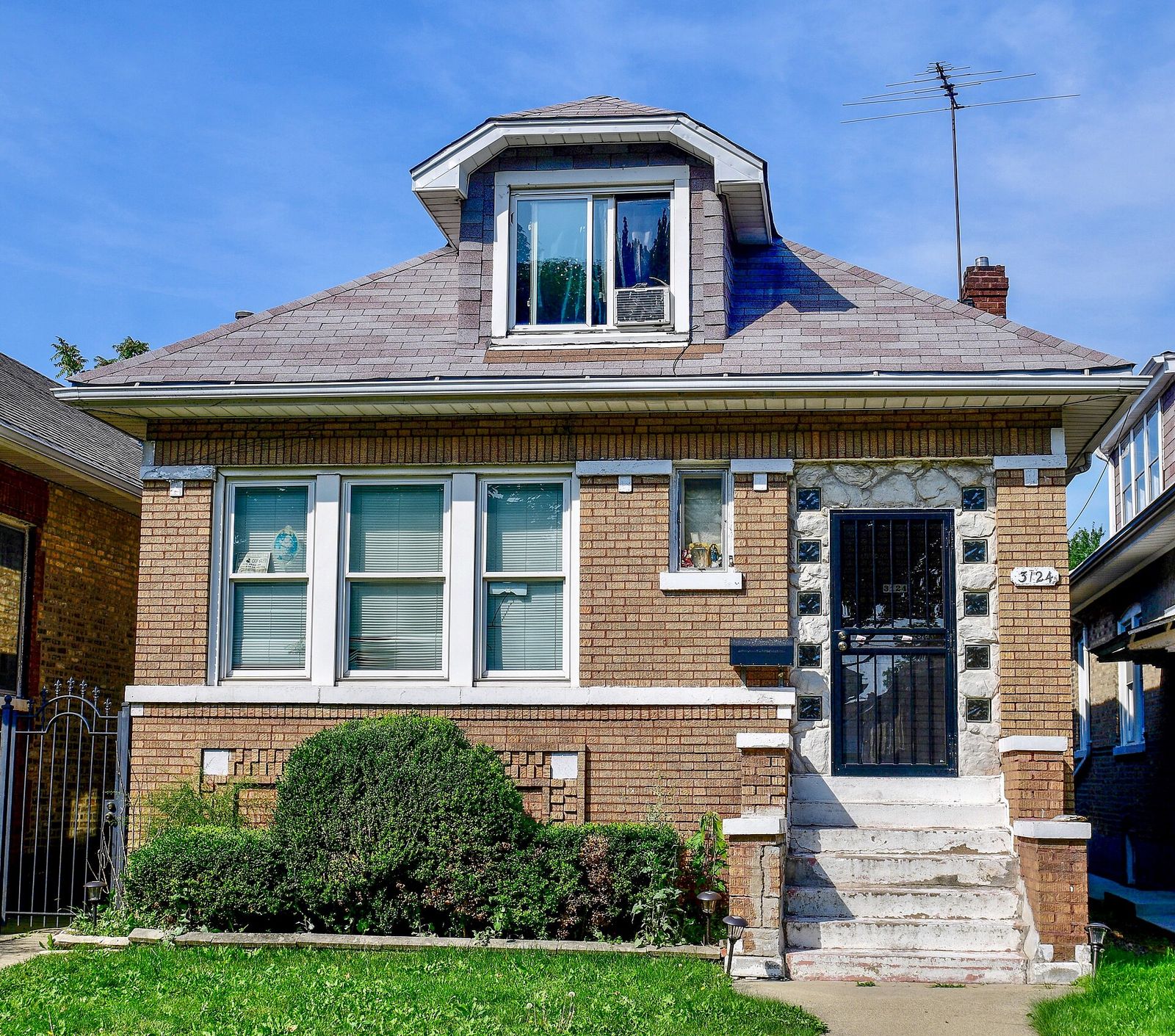 Brown brick Chicago bungalow with a front dormer and stone trim
